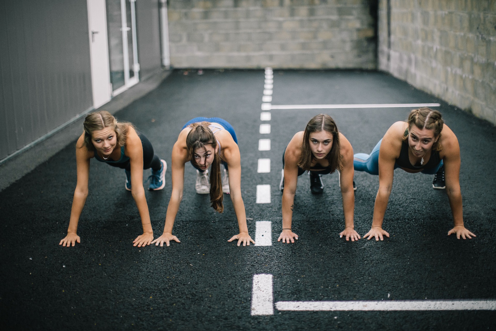 quatre femmes sportives en tenue de sport faisant des pompes au sol